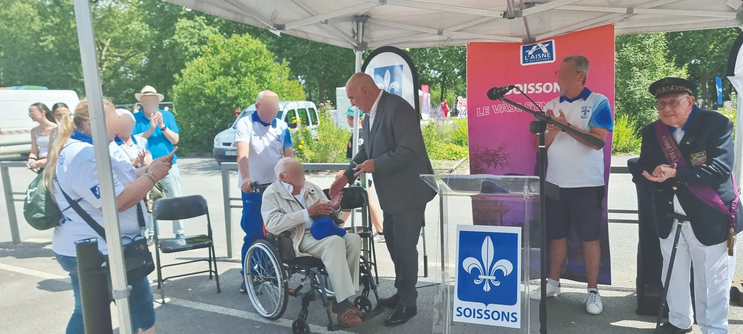 Cérémonie Soissons avec personnes âgées sous tente.