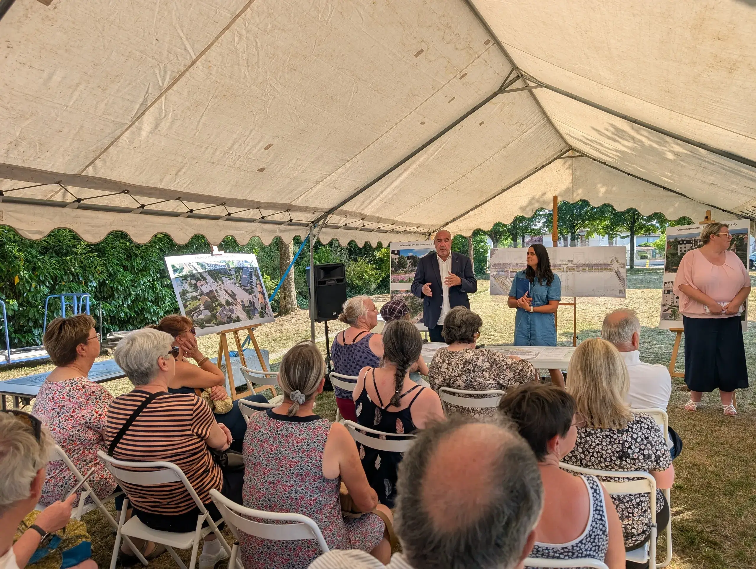 Réunion sous tente avec présentations visuelles.
