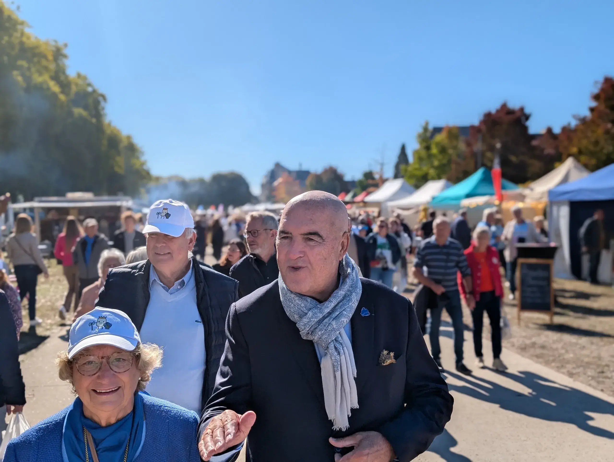 Gens marchant dans un marché ensoleillé.