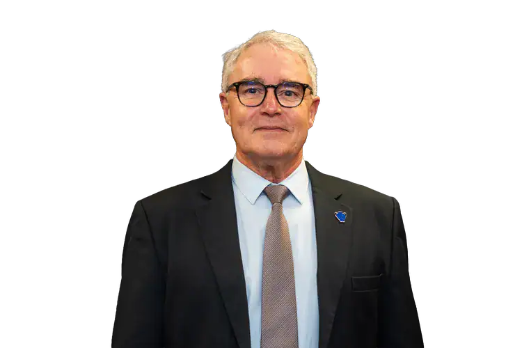 Homme en costume et cravate, portant des lunettes.